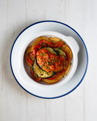 Mallorquin Tumbet. Roasted vegetables with tomato sauce. Top view table with  decoration.