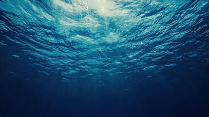 Deep Blue Ocean Underwater Scene with Sunlight Streaming Through the Water Surface