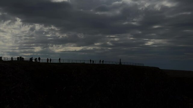 North Cape, Mager&oslash;ya, Nordkapp Municipality, Finnmark, Norway - almost dusk while tourists enjoy the view at sightseeing location on cloudy day