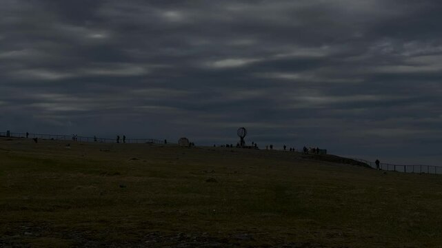 North Cape, Mager&oslash;ya, Nordkapp Municipality, Finnmark, Norway - dusk alsmost darkness at Globe sculpture sightseeing location on cloudy day with few tourists
