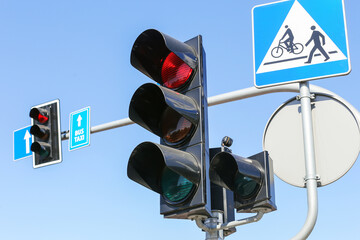 Red traffic light signal. Sunny day intersection. Smart traffic light. City crossing with semaphore. Pedestrian crossing road sign. Good weather road conditions. Blue sky background.