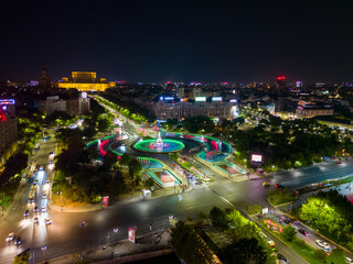 Obraz premium Aerial Drone point of view of Unirii Water Fountains illuminated at night. City center of Bucharest at night. Light shows every weekend, in summer. Capital cities.