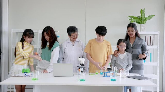Children in science room are having fun while learning about science experiments, everyone stood trial, standing talking with friends About what I just learned, on weekend have take special classes.