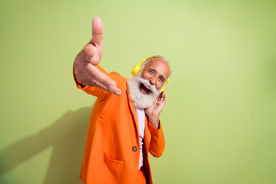 Photo of funny showman good mood headphones mucis wear orange suit isolated on green color background