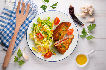Asturian Cachopo. Breaded beef fillet stuffed with cheese and pepper. Top view table with  decoration.