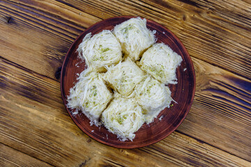 Traditional Turkish dessert Pismaniye on a wooden table. Top view