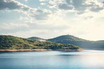 Scenic landscape with a house on a hillside overlooking a lake