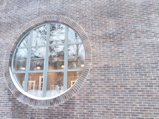 Circular window featuring reflection of winter landscape at a contemporary building