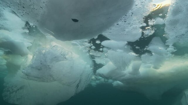 Brash ice, a mix of melting ice beneath the Arctic surface, floats in the cold blue waters. Check my portfolio for more Arctic footage.