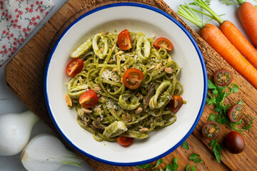 Italian noodles with pesto sauce and squid. Top view table with  decoration.