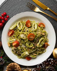 Italian noodles with pesto sauce and squid. Top view table with Christmas decoration.