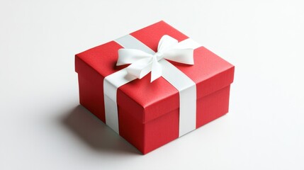 Obraz premium Red New Year gift box with a white ribbon and bow, isolated on a clean white background, creating a festive, celebratory feel.