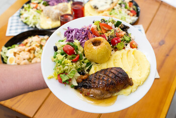 Home made meat dish with salads, in hands dinner time duck and apple