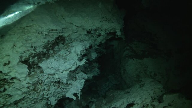 A close-up of a halocline in a cenote, where freshwater meets saltwater, creating a shimmering effect against the rocky surface. Check my portfolio for more cenote footage.