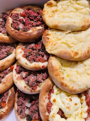 Two delicious esfihas, one filled with meat and another with cheese, resting on a wooden board