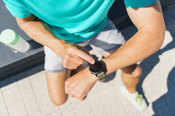 A Person Checking Their Smartwatch While Sitting on a Sunny Outdoor Bench in a Park During the...
