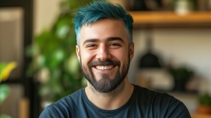 Fototapeta premium Vibrant Blue Hair Styled Young Man Smiling Indoors with Natural Light and Green Background for Modern Lifestyle Concepts