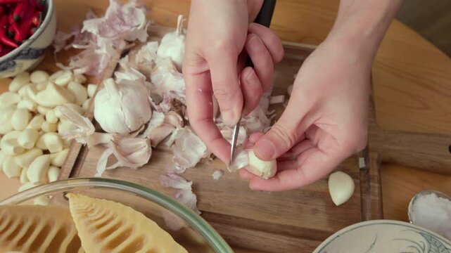 Woman peeling garlic with small knife