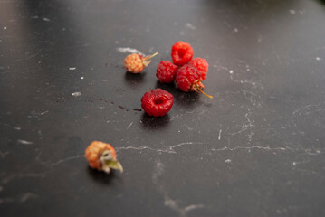 Ripe and unripe raspberries on a bench