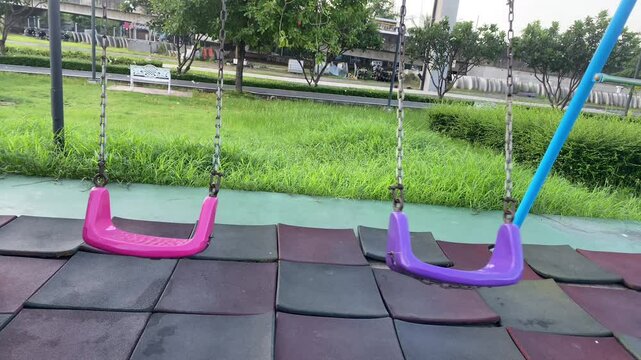 Smooth swinging motion of a wooden swing in a peaceful park, captured in 4K with natural sunlight filtering through trees. Perfect for relaxation, meditation, or background visuals