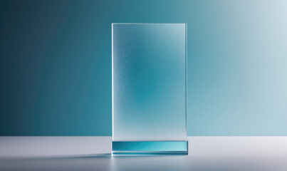 A clear glass plaque stands on a white surface against a light blue background