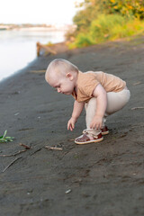 A boy on the shore in the green grass has a picnic
