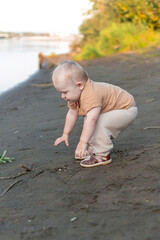 A boy on the shore in the green grass has a picnic