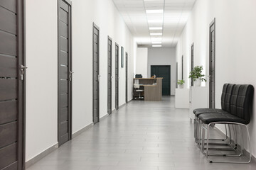 Empty hospital corridor with chairs and doors