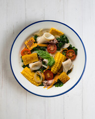 Mediterranean corn salad with squid. Top view table with  decorations.