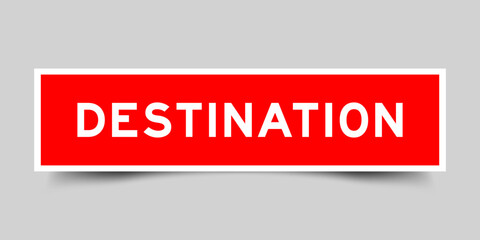 Red color square shape sticker label with word destination on gray background