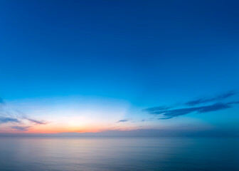 Relaxing and bright background of an intense blue sky over a calm sea during the twilight hour