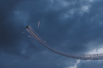Stunt Plane shooting fireworks in the clouds