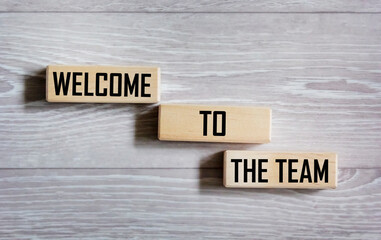 Conceptual words Welcome to the team on a wooden block. On a gray background. Business, motivation and welcome to the team concept.