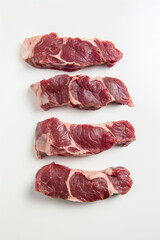 Obraz premium Raw lamb chops arranged on white background, showing fresh meat texture, nutritious protein, culinary concept