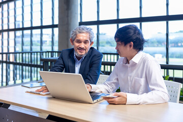 Asian senior professor is giving advice  to the college student on the research thesis while sitting in the university faculty for education, academic and business