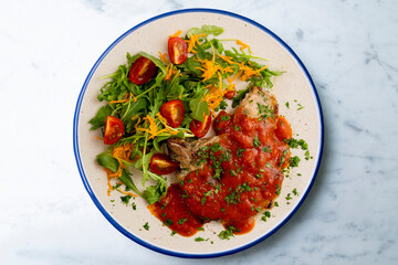 Pork chops with tomato sauce and salad. Top view table with decorations.