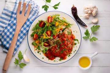 Pork chops with tomato sauce and salad. Top view table with decorations.