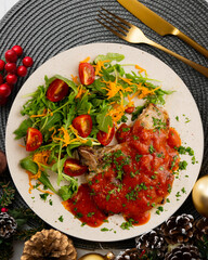 Pork chops with tomato sauce and salad. Top view table with Christmas decorations.