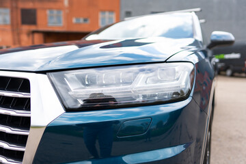 Focus on auto headlights mounted on front of vehicle for illumination of road ahead. Car low beams providing essential safety during drive with visibility at dangerous level