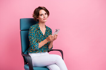 Photo of young influencer girl in smart casual outfit sitting boss chair browsing news x social media isolated on pink color background