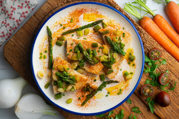 Grilled swordfish with green asparagus. Top view table with  decorations.