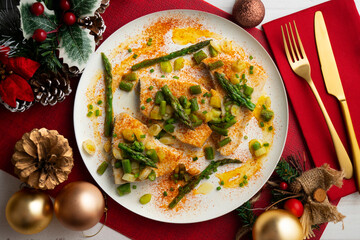 Grilled swordfish with green asparagus. Top view table with Christmas decorations.