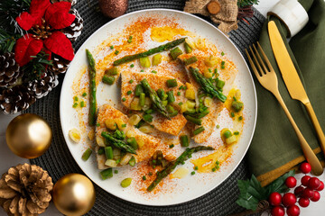 Grilled swordfish with green asparagus. Top view table with Christmas decorations.