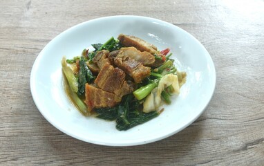 fried Chinese kale and cabbage with crispy pork in soy sauce on plate 