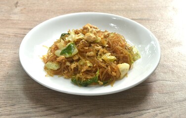 fried glass noodles with egg and cabbage in black sweet soy sauce on plate