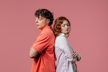 Young offended couple after quarreling, standing back. Selfishness, resentment