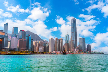 Fototapeta premium City urban view of tall glass skyscrapers in the financial district building, a symbol of the region's economic development, ferris wheel nearby on the embankment strait bay