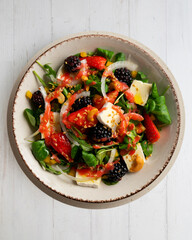 Healthy red berry and brie salad. Top view table with  decorations.
