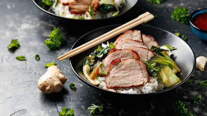 Chinese BBQ Pork Char Siu with rice and bok choy in a black bowl