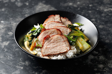 Chinese BBQ Pork Char Siu with rice and bok choy in a black bowl